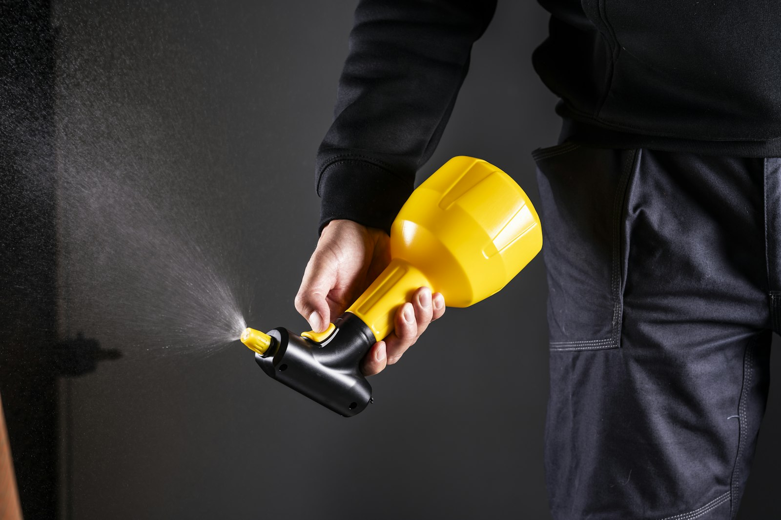 Pest control technician using a spray gun